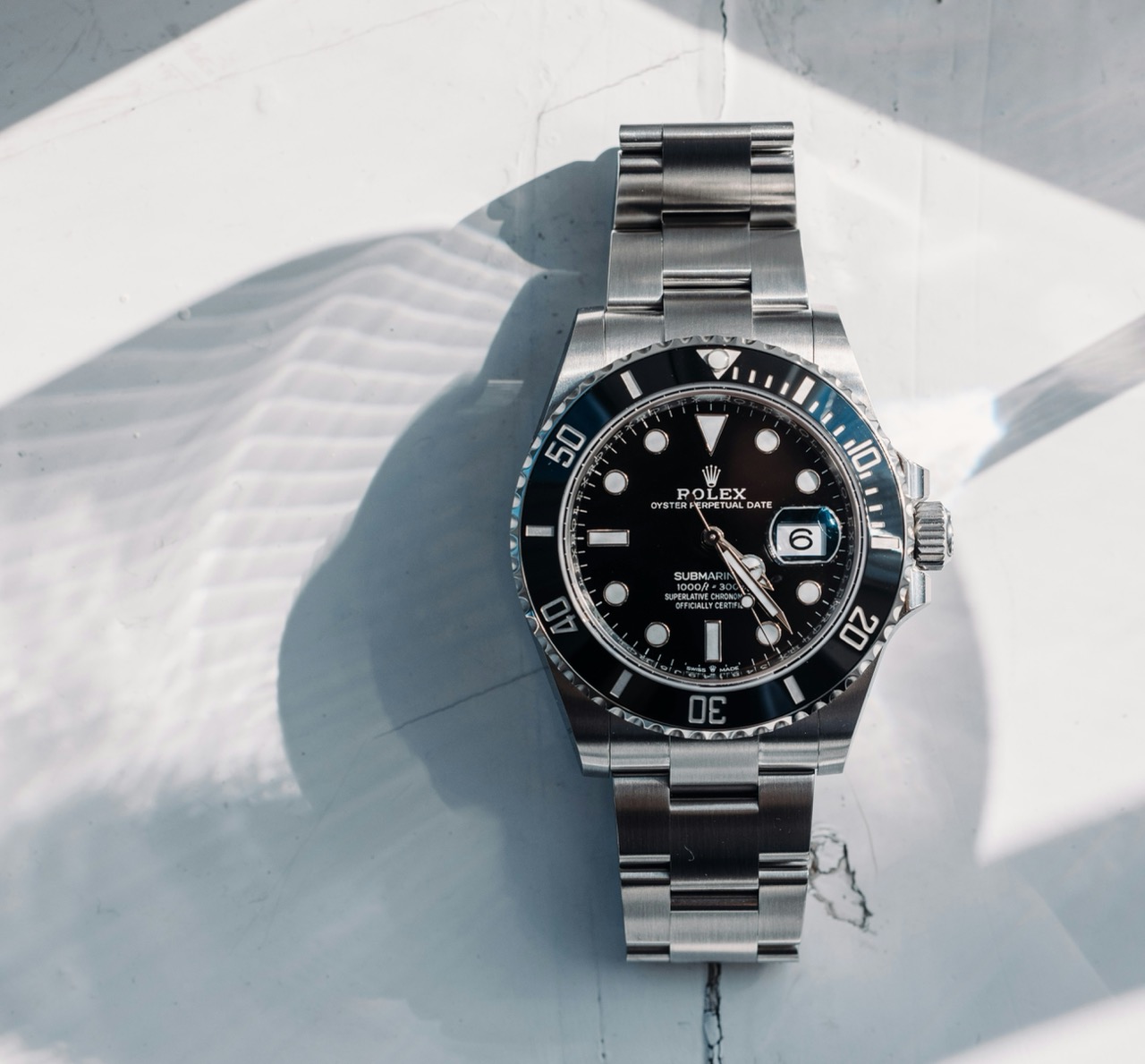 Rolex Submariner in raking light on a textured surface